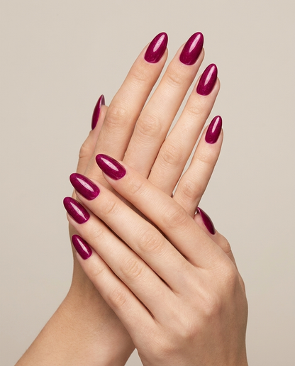 Hands with MineVital Naughty C26 manicure — deep magenta-fuchsia shimmer water-based breathable nail polish on natural nails
